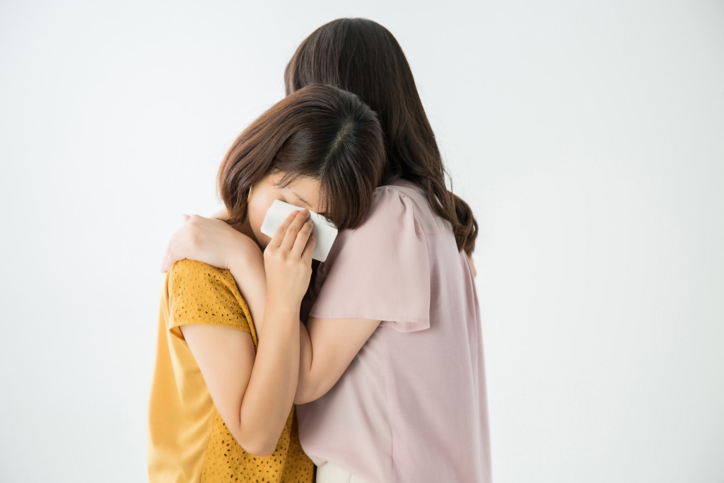 A woman comforting a grieving/crying woman