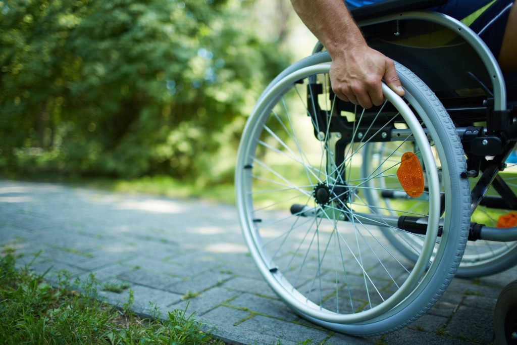 male hand on wheel of wheelchair during walk