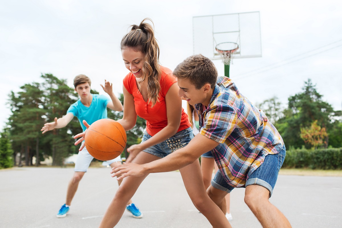 teens playing basketball in the public court