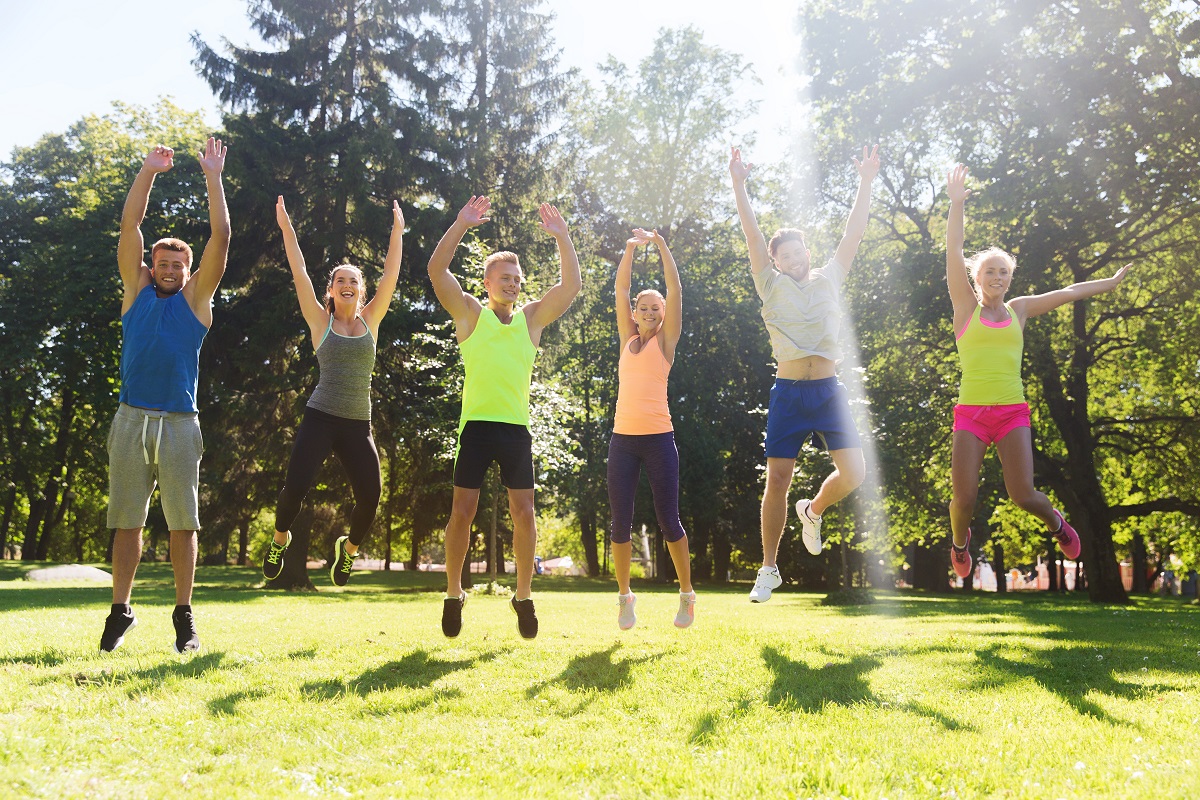 group of friends jumping high outdoors