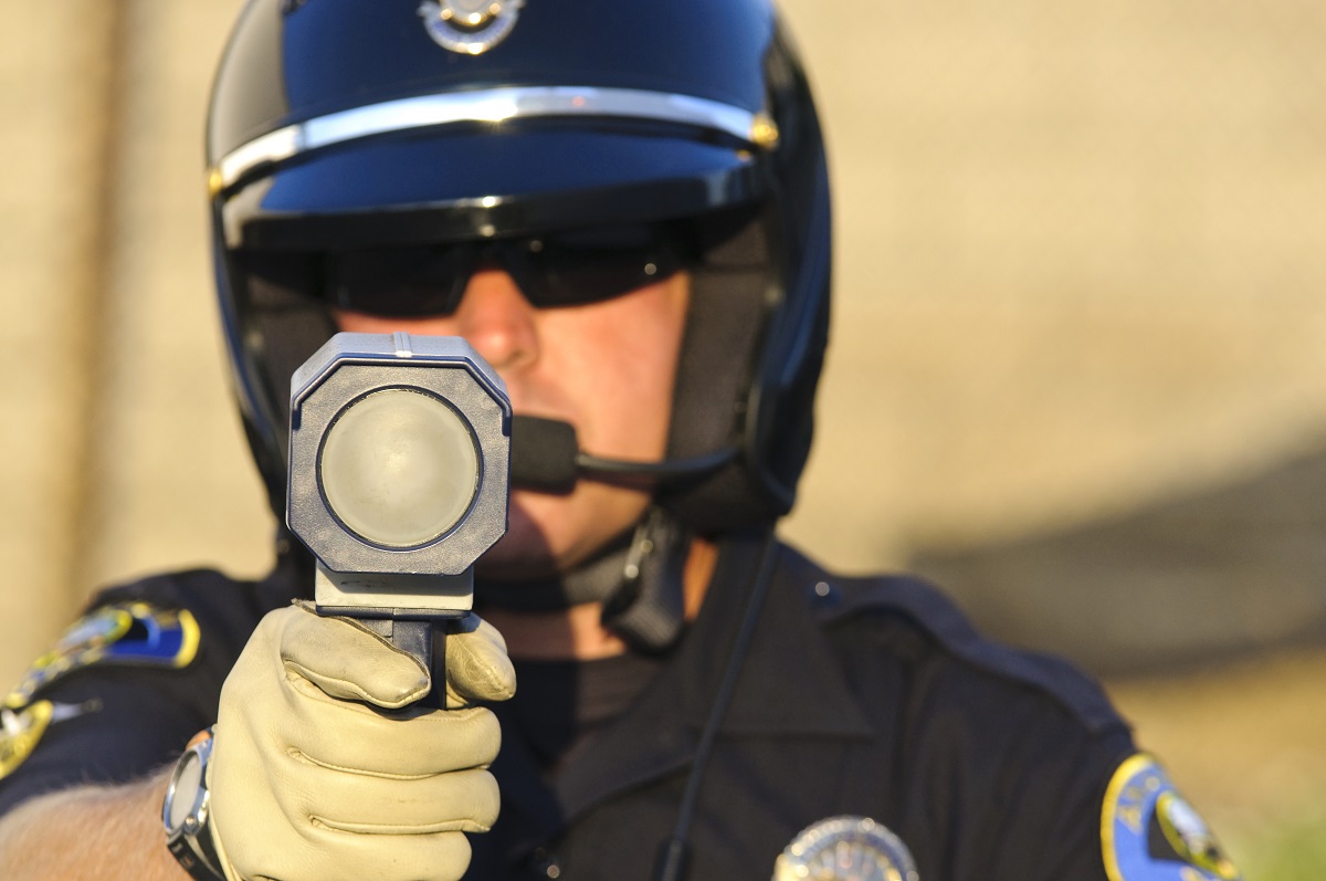 A police pointing a radar gun