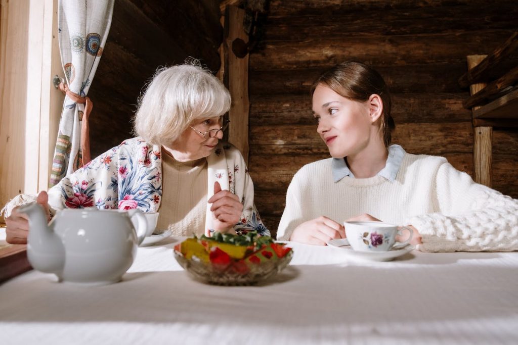 Grandmother and a Teenager Having Tea Together